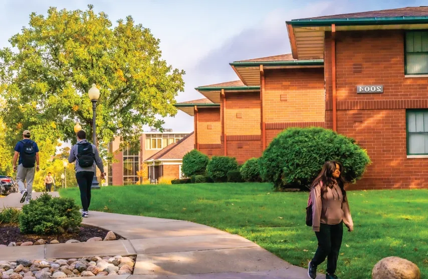 Students walking outside near campus houses.